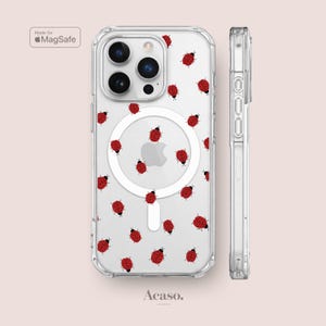 Könnte beinhalten: Eine transparente Handyhülle mit einem wiederkehrenden Muster aus kleinen roten Marienkäfern mit schwarzen Punkten. Die Hülle verfügt über einen weißen, kreisförmigen MagSafe-Magnetring auf der Rückseite und eine Seitenansicht. Der Text lautet Made for MagSafe.