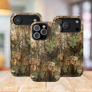 May include: Three smartphone cases featuring a stained glass-style pattern of brown tree bark and green oak leaves. The cases have black camera cutouts and protective edges, displaying a detailed, segmented design with dark outlines throughout.