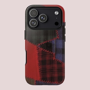 May include: A phone case with a patchwork design featuring red, black, and blue plaid patterns. The case has a black border and a camera cutout. The design includes a red section with visible stitching.