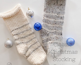 May include: Two knitted Christmas stockings with white and gray stripes. The stockings are on a white background with silver and blue ornaments.