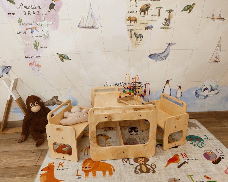 Puede incluir: Una mesa de juego de madera con dos bancos unidos y un laberinto de cuentas de colores en el centro. La mesa y los bancos son de color madera natural. La mesa est&aacute; sobre una alfombra con ilustraciones de animales y letras.