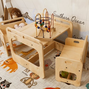 Puede incluir: Un juego de mesa y sillas de madera para ni&ntilde;os. La mesa tiene una tapa cuadrada y est&aacute; rodeada de tres sillas. La mesa tiene un recorte en el lateral y las sillas tienen un recorte en la parte posterior. La mesa est&aacute; hecha de madera natural y tiene un acabado marr&oacute;n claro. Las sillas tambi&eacute;n est&aacute;n hechas de madera natural y tienen un acabado marr&oacute;n claro. La mesa y las sillas est&aacute;n sobre una alfombra con un dise&ntilde;o de alfabeto colorido. El texto "Southern Ocean" est&aacute; escrito en el lateral de la mesa.