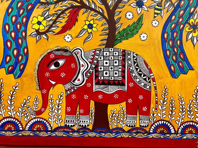 Puede incluir: Una pintura de arte popular colorida de un elefante rojo con detalles en blanco y negro de pie frente a un fondo amarillo con un &aacute;rbol verde y pavos reales azules. El elefante tiene un ojo blanco y una defensa blanca. La pintura est&aacute; enmarcada en un marco rojo y dorado.