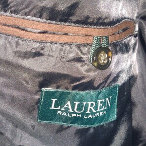 May include: A green label with white text that reads "LAUREN RALPH LAUREN" on a black fabric background.