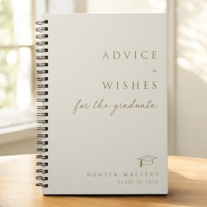 May include: A spiral-bound notebook with a cream-colored cover. The cover features the words "ADVICE + WISHES for the graduate" in a gold color, along with a graduation cap graphic and the name "HUNTER WALTERS CLASS OF 2025".