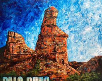 May include: A painting of a red rock formation called Palo Duro Canyon, with a blue sky in the background.