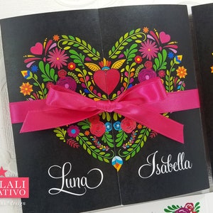 May include: A black card with a pink ribbon tied in a bow. The card features a colorful heart design with flowers and leaves. The text "Luna" and "Isabella" are written on the card.