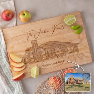 Puede incluir: Una tabla de cortar de madera personalizada con una ilustraci&oacute;n grabada con l&aacute;ser de una casa y el texto "The Jackson Family 183 John Chisholm Rd".