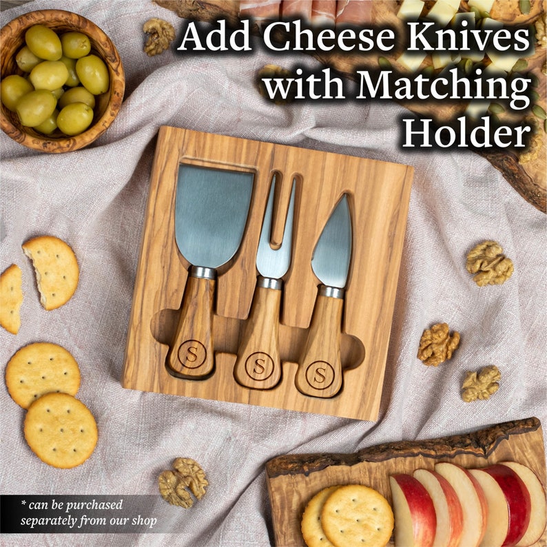 Op de afbeelding: Een houten kaasmesjesset met drie roestvrijstalen messen en houten handvatten, elk gegraveerd met de letter "S". De set wordt gepresenteerd in een bijpassende houten houder. De tekst "Add Cheese Knives with Matching Holder" is zichtbaar.