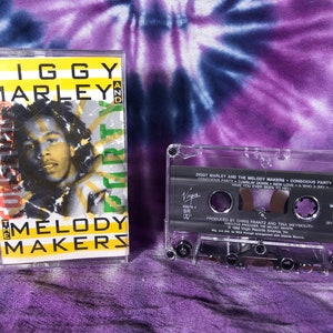 May include: A cassette tape of Ziggy Marley and the Melody Makers' album "Conscious Party". The tape is in a clear plastic case with a black label. The label features the album title, artist names, and a photo of Ziggy Marley.