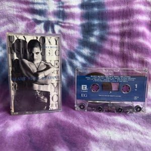 Puede incluir: Dos cintas de casete de Roxy Music. Una funda presenta una imagen en blanco y negro de una persona con el texto "ROXY MUSIC HEART STILL BEATING". La otra cinta de casete tiene una etiqueta azul con títulos de canciones.