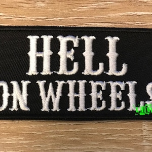 May include: Black embroidered patch with white lettering that reads "Hell on Wheels".