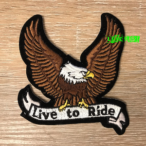 Puede incluir: Parche bordado con un águila marrón con cabeza blanca y pico amarillo, alas extendidas y una pancarta blanca con el texto "Live to Ride".