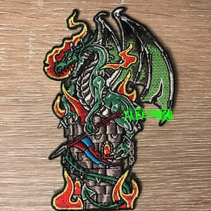 May include: Green dragon embroidered patch with red and yellow flames, holding a sword and perched on a stone tower.
