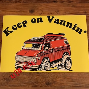 May include: A yellow poster with the text "Keep on Vanning." in black letters. A red and black cartoon van is featured on the poster.