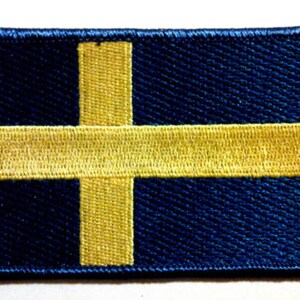 May include: A blue and yellow embroidered patch featuring the flag of Sweden.