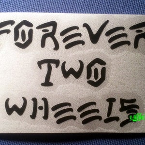 May include: Black and white sticker with the words "FOREVER TWO WHEELS" in a stylized font. The sticker also includes the words "LIVE FAST" in green.