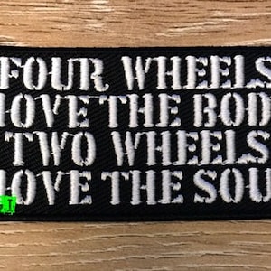 Könnte beinhalten: Schwarzer gestickter Aufnäher mit weißem Text, der "Four wheels move the body two wheels move the soul." lautet.