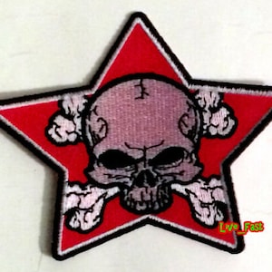 Op de afbeelding: Rode stervormige patch met een wit schedel- en kruisbeenderontwerp. De schedel is grijs en de kruisbeenderen zijn wit. De tekst "Live Fast" is zichtbaar in de rechterbenedenhoek van de patch.
