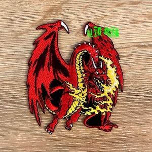 May include: Red embroidered iron-on patch of a dragon with yellow flames. The dragon is facing right and has its wings spread out.