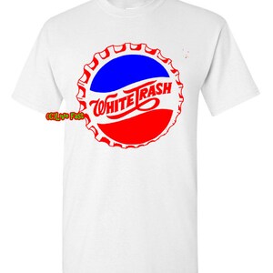 May include: White T-shirt featuring a red, white and blue bottle top design. The bottle top has the words "White Trash" written on it. The text "(C) Live Fast" is written in green below the bottle top.