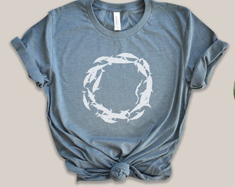 Könnte beinhalten: Ein heidefarbenes T-Shirt mit einer weißen Grafik eines Fischkreises.