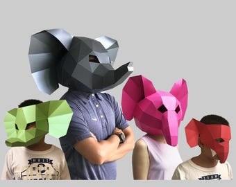 May include: Four people wearing paper mache elephant masks. The masks are in different colors: black, green, pink, and red. The people are wearing casual clothing.