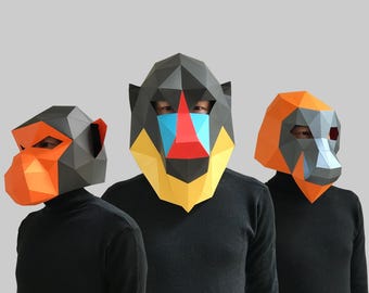 May include: Three paper mache animal masks. The masks are of a mandrill, a baboon, and a red-capped mangabey. The masks are all black, orange, and yellow.