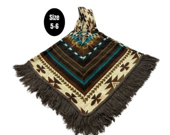 Könnte beinhalten: Ein braunes, blaues und weißes Poncho mit Fransenbesatz. Das Poncho hat eine Kapuze und ein schwarzes Etikett mit der Aufschrift "Größe 5-6".