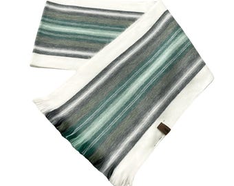 May include: White alpaca wool scarf with green, gray, and white stripes. The scarf has a fringe on the ends.