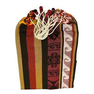 May include: A patterned drawstring bag with a vibrant design. The bag showcases vertical stripes in brown, red, and yellow, alongside a patterned section in burgundy and white. It has a white drawstring and colourful woven accents at the top.