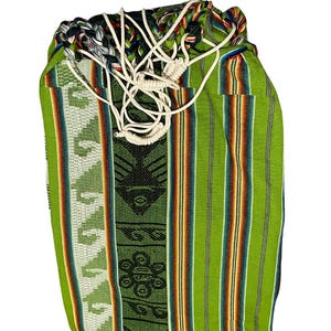 May include: A green and multi-coloured woven drawstring bag. The bag features vertical stripes and geometric patterns in shades of green, orange, and black. White rope-like drawstrings are visible at the top.