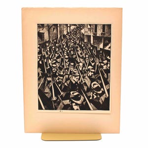 May include: Black and white print of a crowd of people marching with swords. The artwork is a linocut or woodcut style, with bold lines and a strong contrast between light and dark areas. The print is mounted on a cream-colored paper.