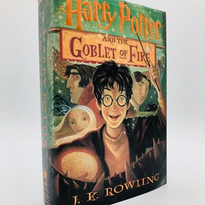 May include: A green, orange, and black book cover with the title "Harry Potter and the Goblet of Fire" by J.K. Rowling. The cover features an illustration of Harry Potter with other characters from the book.