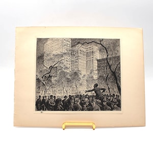 Peut inclure: Gravure en noir et blanc d'une scène urbaine avec une foule et de grands immeubles en arrière-plan. Une figure fait un geste vers la foule. La gravure est montée sur un passe-partout crème.