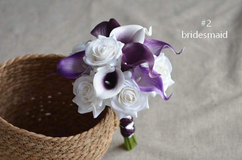 May include: A bridal bouquet with white roses and purple calla lilies. #2 bridesmaid