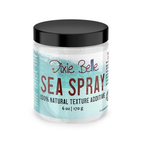 May include: A white jar with a black lid containing a white, glittery substance. The jar has a blue and white ocean wave design with the text "Dixie Belle SEA SPRAY 100% NATURAL TEXTURE ADDITIVE 6 oz | 170 g".