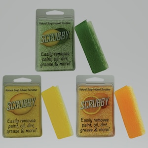 May include: Three packages of natural soap infused scrubbers. Each package has a green, yellow, or orange scrubber and features the text "SCRUBBY" and "Easily removes paint, oil, dirt, grease & more!"