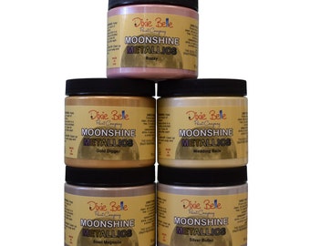 May include: Four glass jars of Dixie Belle Moonshine Metallic paint. The jars are labeled with the colors: Rozay, Gold Digger, Wedding Bells, Steel Magnolia, and Silver Bullet.