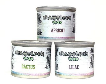 May include: Three round jars of Chameleon Wax, labeled with the scents Apricot, Cactus, and Lilac. The jars are white with a light brown woodgrain pattern.