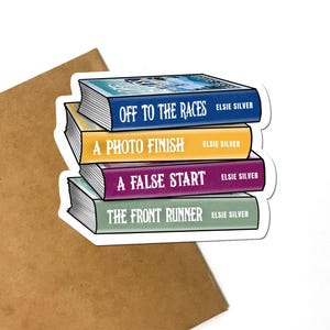 May include: A sticker featuring a stack of four books with titles: "Off to the Races," "A Photo Finish," "A False Start," and "The Front Runner." Each book has the author's name, Elsie Silver, printed on the spine. The books are in shades of blue, yellow, purple, and green.