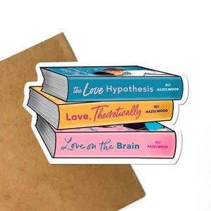 May include: A sticker featuring three stacked books with the titles "The Love Hypothesis", "Love, Theoretically", and "Love on the Brain". Each book has a different color spine: blue, yellow, and pink. The author's name, Ali Hazelwood, is printed on each book.