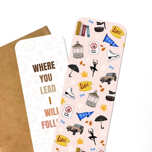 May include: A pink bookmark with a pattern of fall-themed illustrations, including a coffee cup, a gazebo, a jeep, a pair of ice skates, a ballerina, an umbrella, and the words "Luke's" and "Yale". The bookmark also has the text "Where you lead I will follow" on a white background.