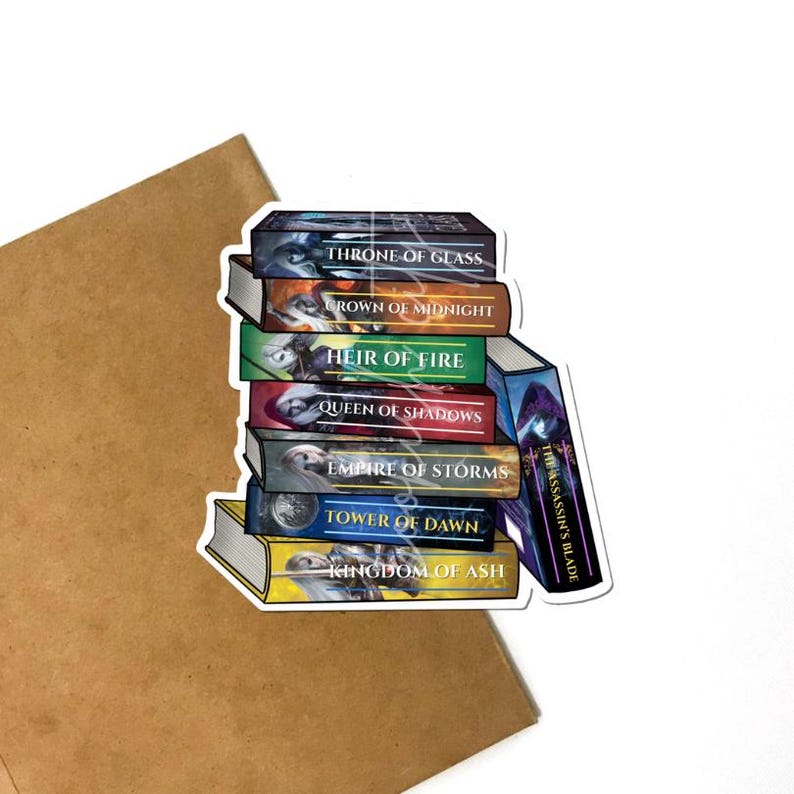 May include: A sticker featuring a stack of fantasy book covers with titles like "Throne of Glass" and "Kingdom of Ash." The books are in various colors, including blue, green, and yellow, with detailed illustrations. The sticker is on a white background.