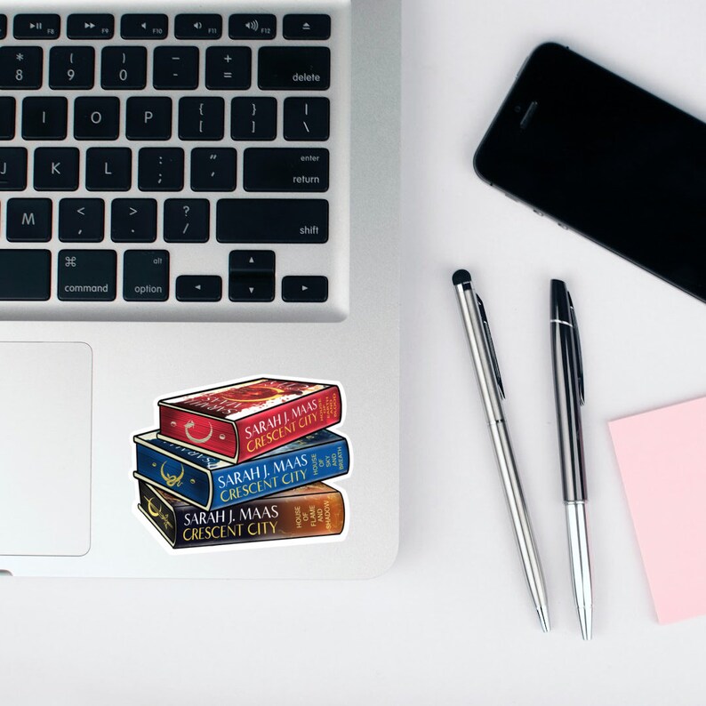 Peut inclure: Une pile de quatre livres broch&eacute;s avec des couvertures bleues, rouges et blanches. Les livres sont intitul&eacute;s "Crescent City" par Sarah J. Maas.