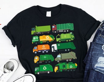 May include: A black t-shirt with a graphic of multiple green, yellow, and orange garbage trucks with recycling symbols. The trucks are arranged vertically on the shirt.