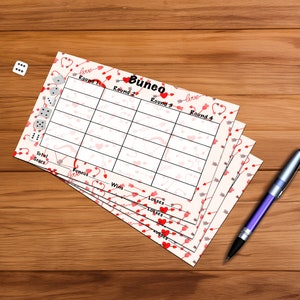 Puede incluir: Un juego de cuatro tarjetas de puntuación Bunco con temática de San Valentín con un fondo rosa y blanco con corazones y flechas rojas. Las tarjetas de puntuación están etiquetadas como "Ronda 1", "Ronda 2", "Ronda 3" y "Ronda 4".
