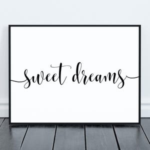 May include: A black framed print with the text "sweet dreams" in a cursive font on a white background.
