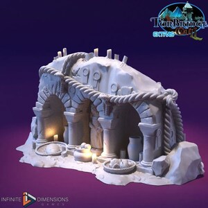 Pode incluir: Uma miniatura de arco de pedra branca impressa em 3D com um detalhe de corda. O arco tem duas colunas e uma pequena estátua no interior. A miniatura está colocada sobre uma base branca.