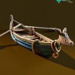 May include: A wooden rowboat with a deer head prow, blue and green paint, and two oars. The boat is on a brown surface.